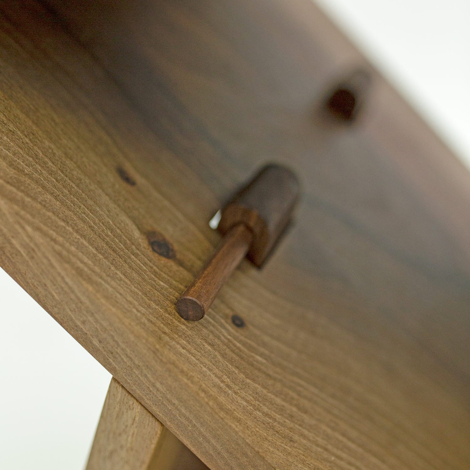 Seitliche Detailaufnahme der Verbindungsstifte vom Hocker "Holzweg", gestaltet von Marius Uminski, Variante aus Walnussholz