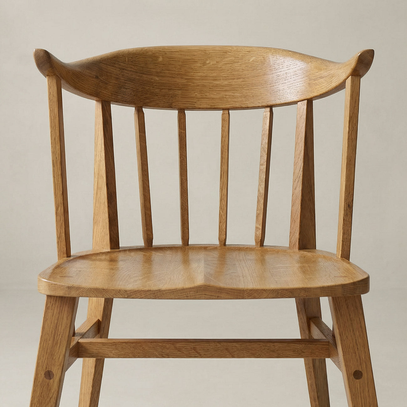 Eine Nahaufnahme des Eichenholz Stuhl Norderney, die die Details der Holzmaserung und die handwerkliche Verarbeitung der Sitzfläche und der Rückenlehne zeigt.