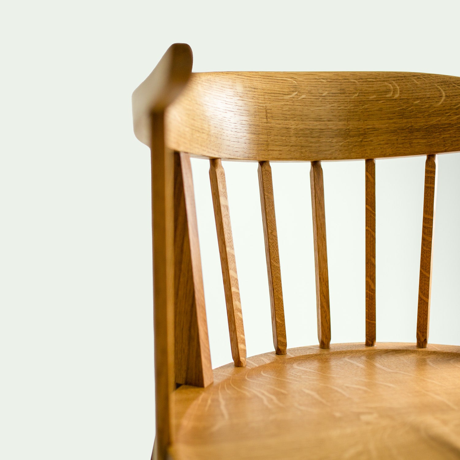 Ein Detailbild der Rückenlehne des Stuhls Norderney, das die geschwungene Form und die sorgfältig gearbeiteten Streben hervorhebt.