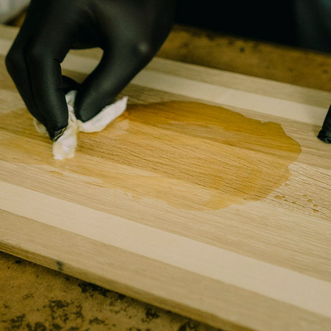 Leinöl wird zur richtigen Holzpflege auf die Oberfläche verteilt