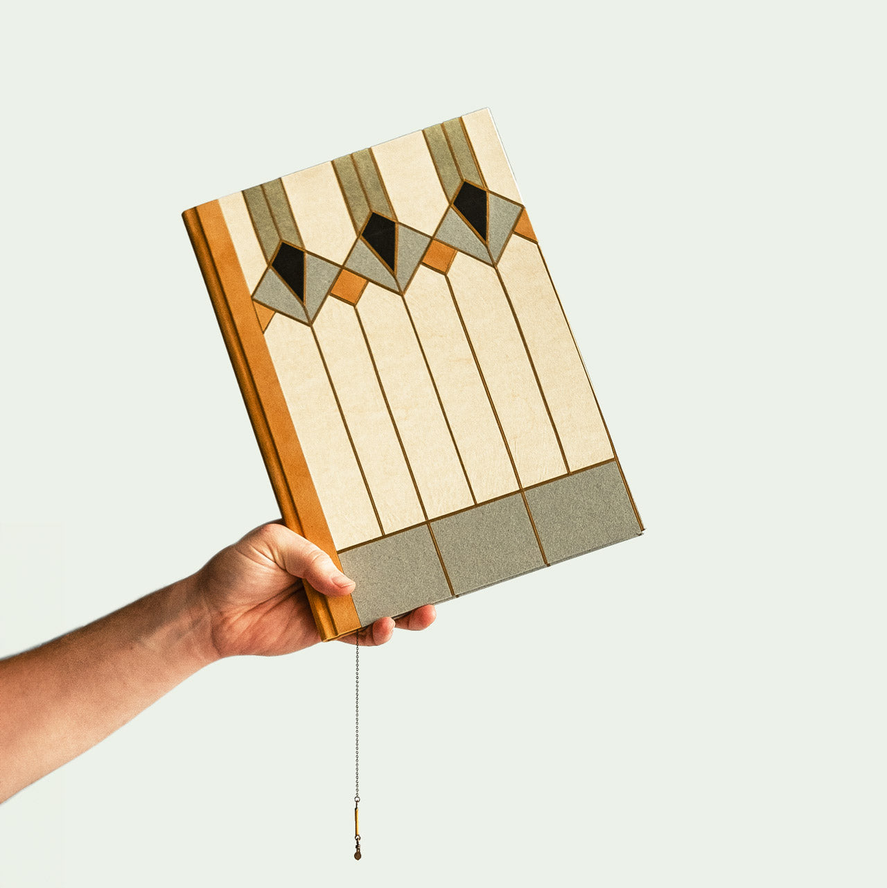 Hand hält ein Kunstbuch von Christa Jung mit geometrischem Design.