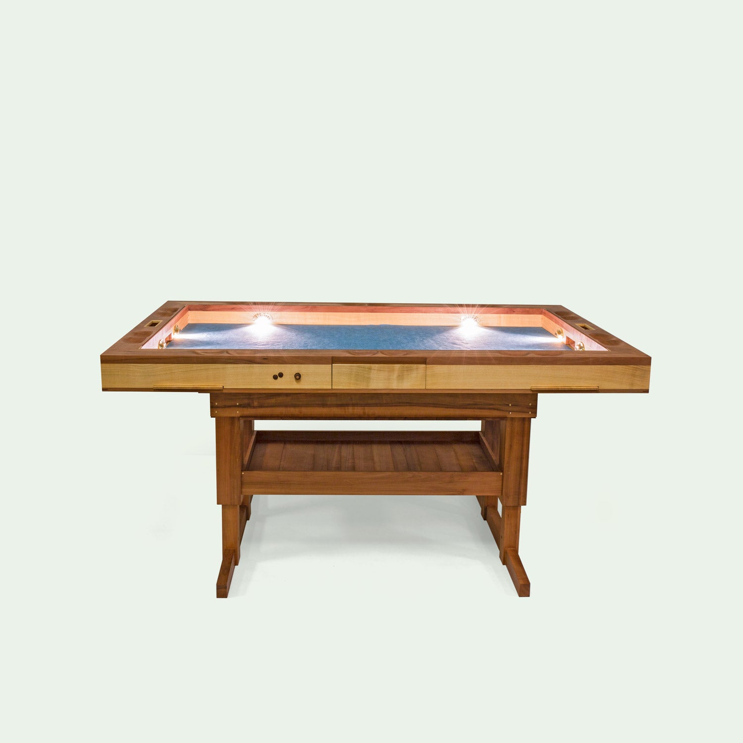 Sicht auf die Längsseite den Spieletisches Corbin, einem elektrisch höhenverstellbaren Spieletisch von mimikry. gefertigt aus Elsbeeren Holz und Kirschholz. Die integrierten Lichter des Spieletisches sind zu demonstrationszwecken angeschlatet.