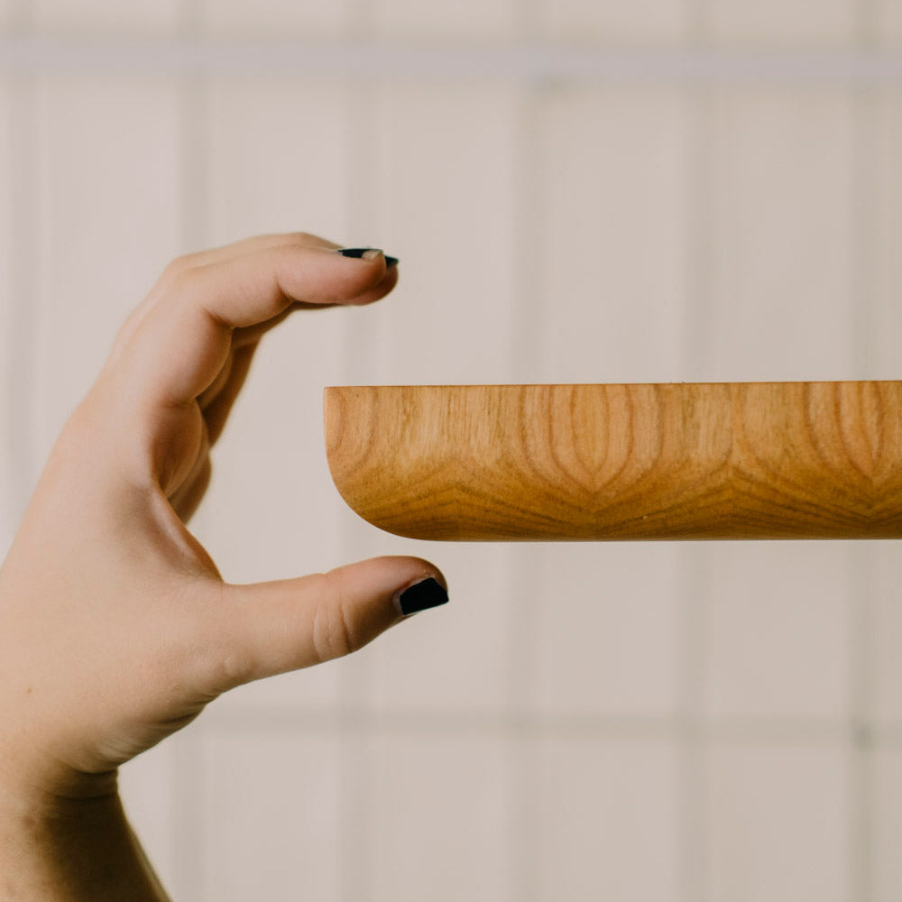 Blick auf die Seite eines Hirnholz Schneidebrettes aus Eiche mit einer Hand, die anzeigt wie Dick dass Schneidebrett ist
