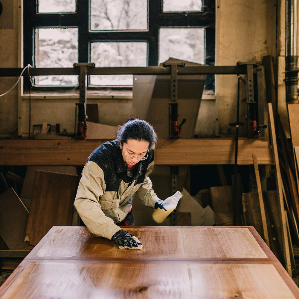 Ein Tischler in Leipzig beim Ölen einer Holz Tischplatte