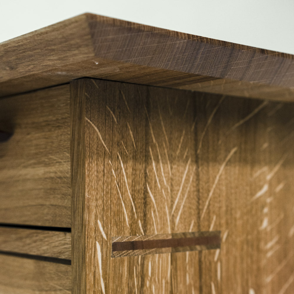 Seitenansicht eines Möbelstücks mit durchgestemmtem Zapfen – sichtbare, traditionelle Holzverbindung in handwerklicher Ausführung