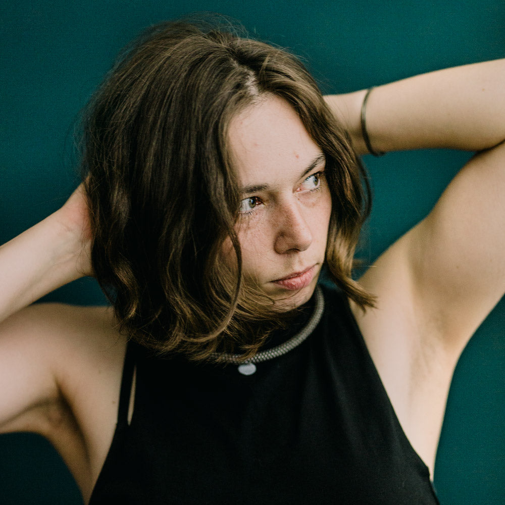 Atmosphärisches Portrait von Victoria Hilsberger, die sich gerade die Haare zurecht macht. Sie ist Mitorganisatorin der Leipziger Kulturmesse