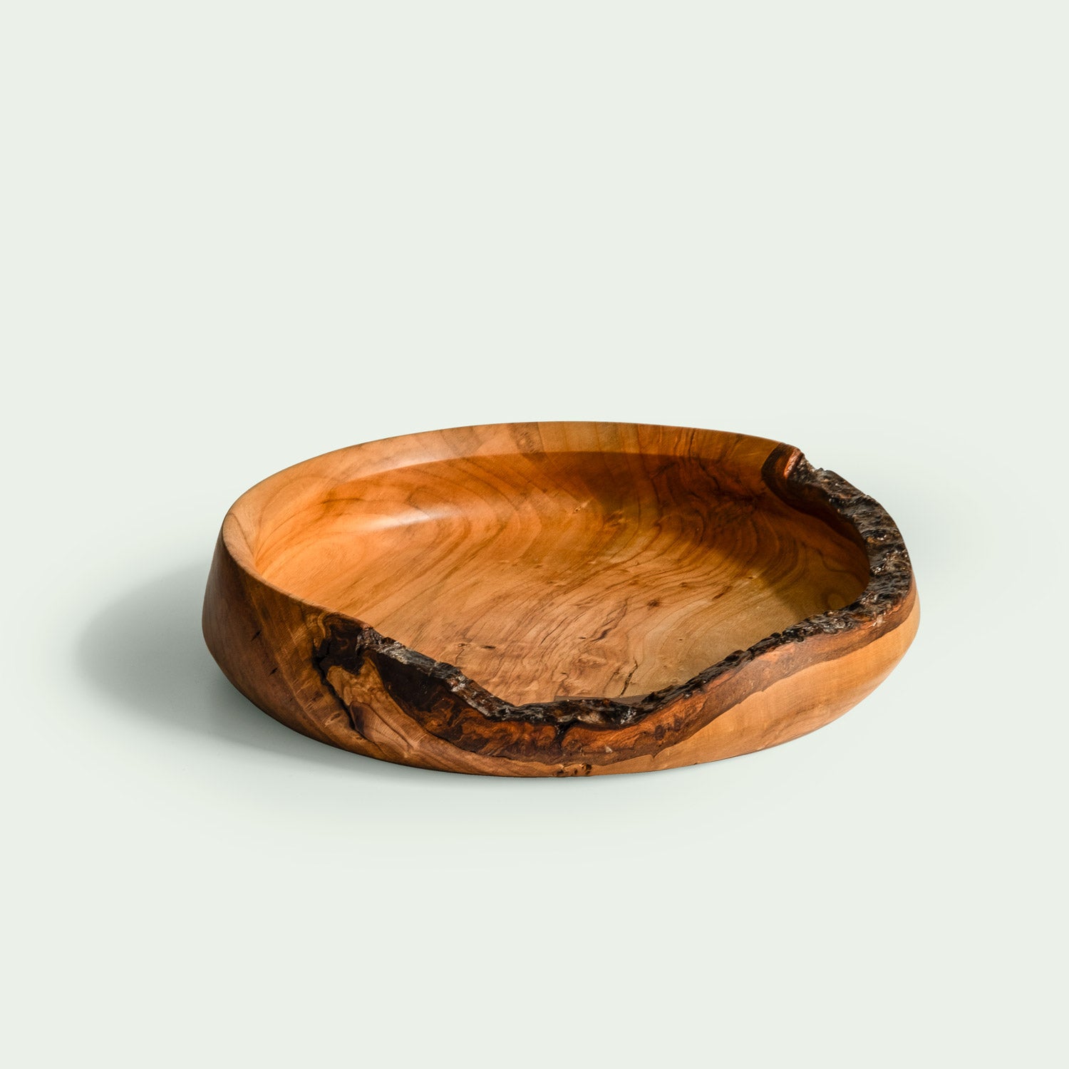 Handgefertigte Holzschale aus Kirschholz mit rustikalem Holzrand in stilvoller Form.