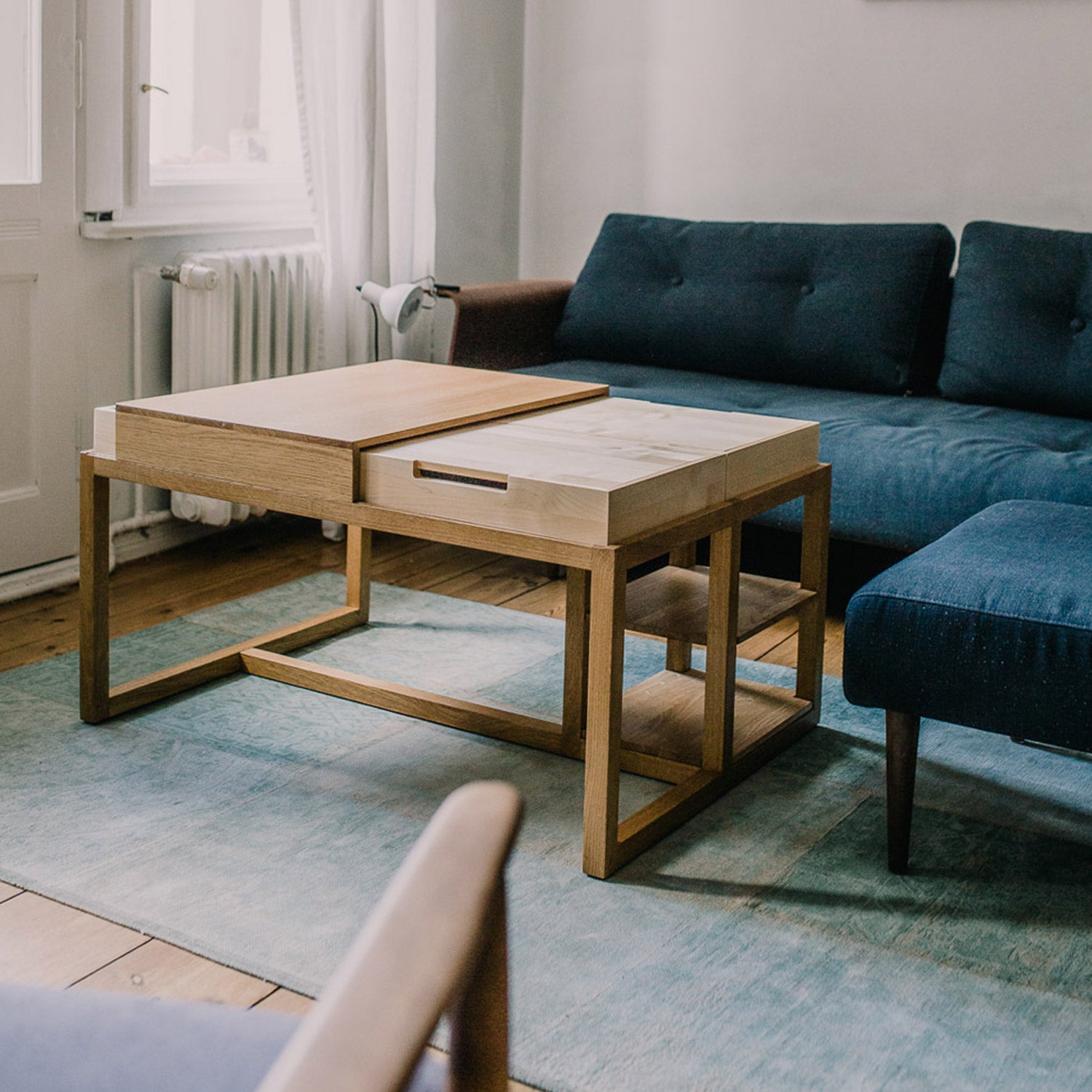 Moderner Holztisch "Din" von mimikry, in einem Wohnzimmer mit blauen Sofas und einem hellen Teppich.