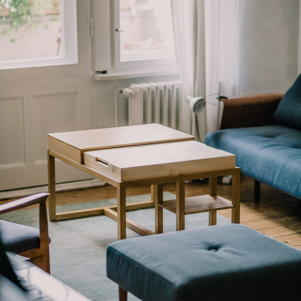 Moderner Holztisch "Din" von mimikry in einem Wohnzimmer mit blauen Sofas und einem hellen Teppich, Detailansicht.