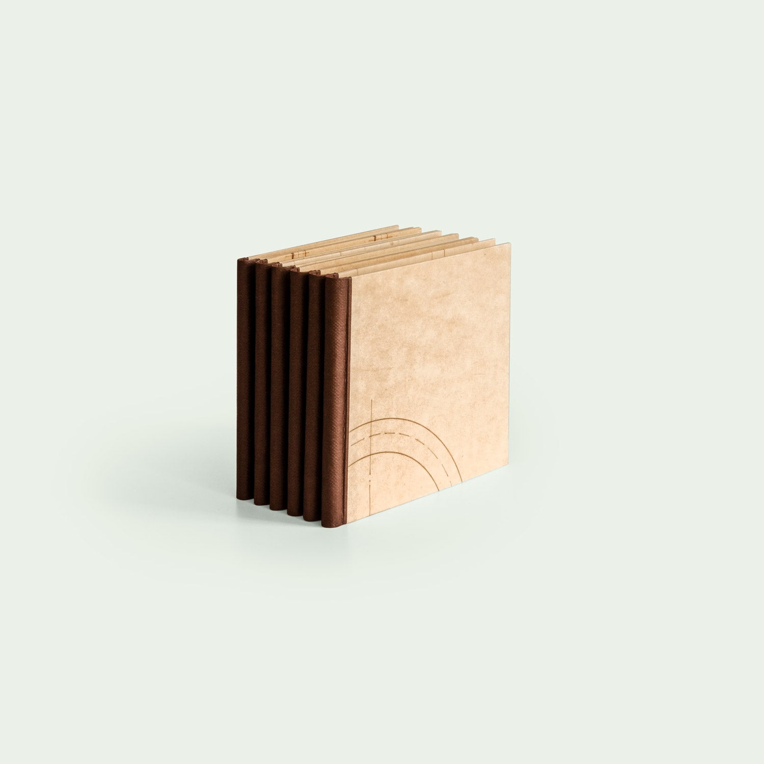 Eine Gruppe von sechs handgefertigten Notizbüchern wird in einer Reihe aufgestellt und zeigt die braunen Buchrücken und das schlichte Design der Einbände.