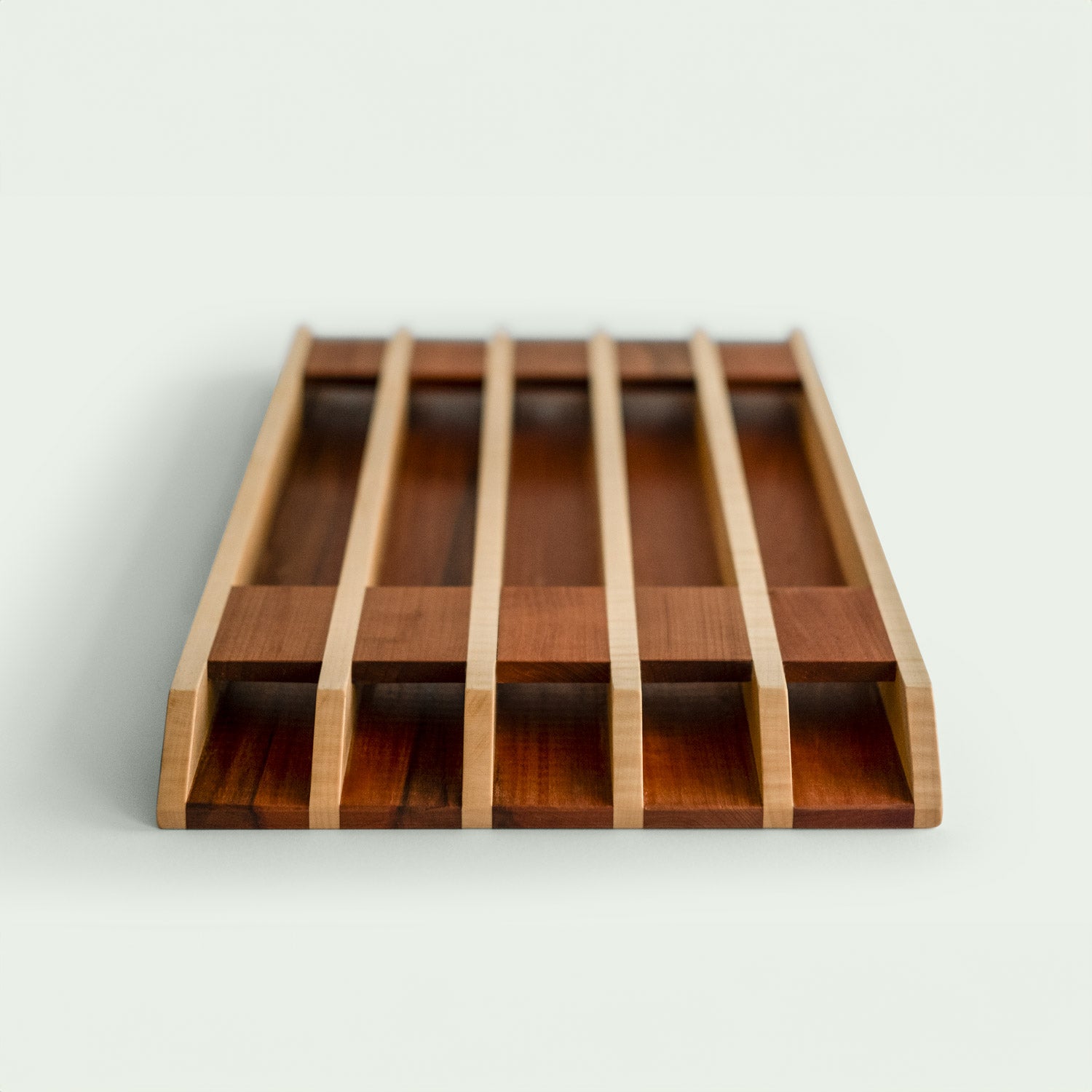 Detailansicht eines Holzschneidebretts mit gestreiftem Muster aus Ahorn und Elsbeere, Perspektivansicht auf die Unterseite, Rippenkonstruktion