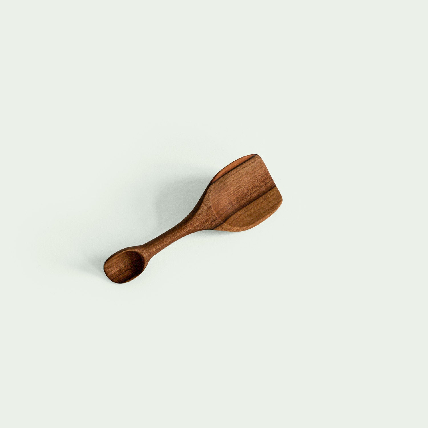 Doppelseitige Salzschaufel aus Elsbeere, seitlich liegend, handgefertigt und nachhaltig produziert, mit ergonomischem Design.
