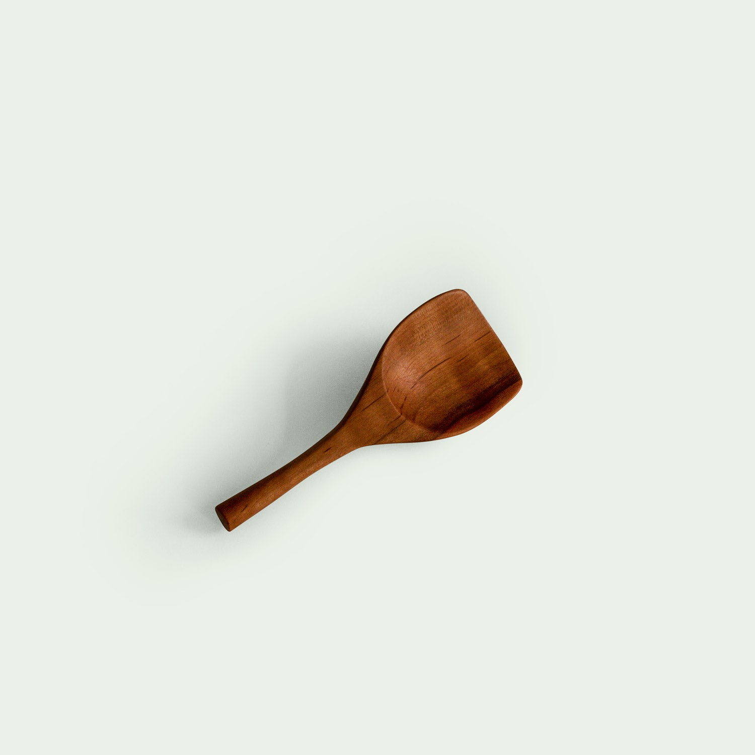Handgefertigte Salzschaufel aus Elsbeere, liegend, nachhaltig produziert, mit ergonomischem Design.
