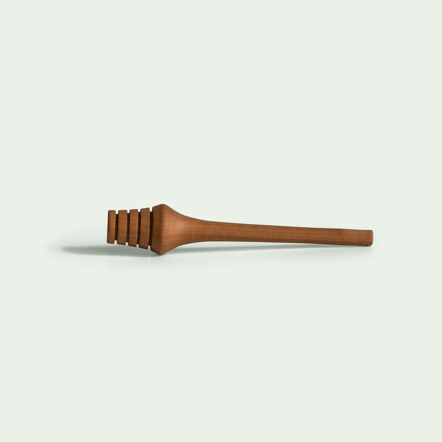 Ein Honiglöffel aus der Serie "Elsbeere" wird von der Seite gezeigt, um das schlanke, ergonomische Design zu betonen.