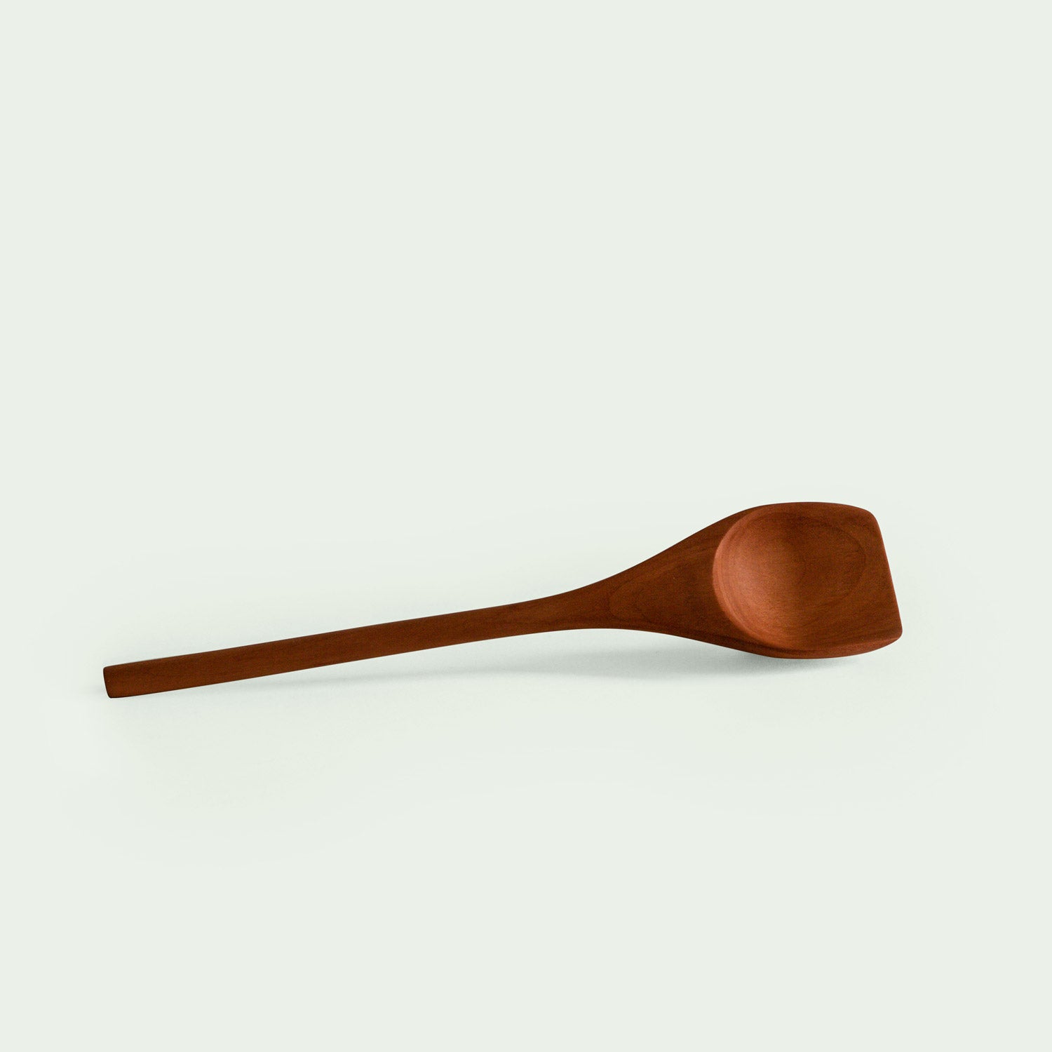 Handgefertigter Löffel aus Elsbeere, liegend, mit elegant geschwungenem Design und glatter Oberfläche, nachhaltig produziert.