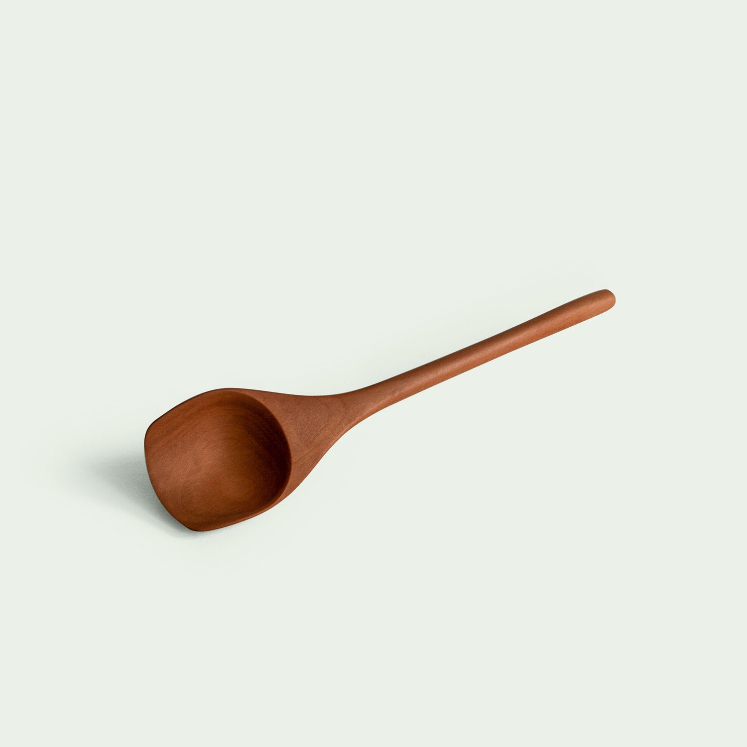 Handgefertigter Löffel aus Elsbeere, liegend in Draufsicht, mit elegant geschwungenem Design und glatter Oberfläche, nachhaltig produziert.