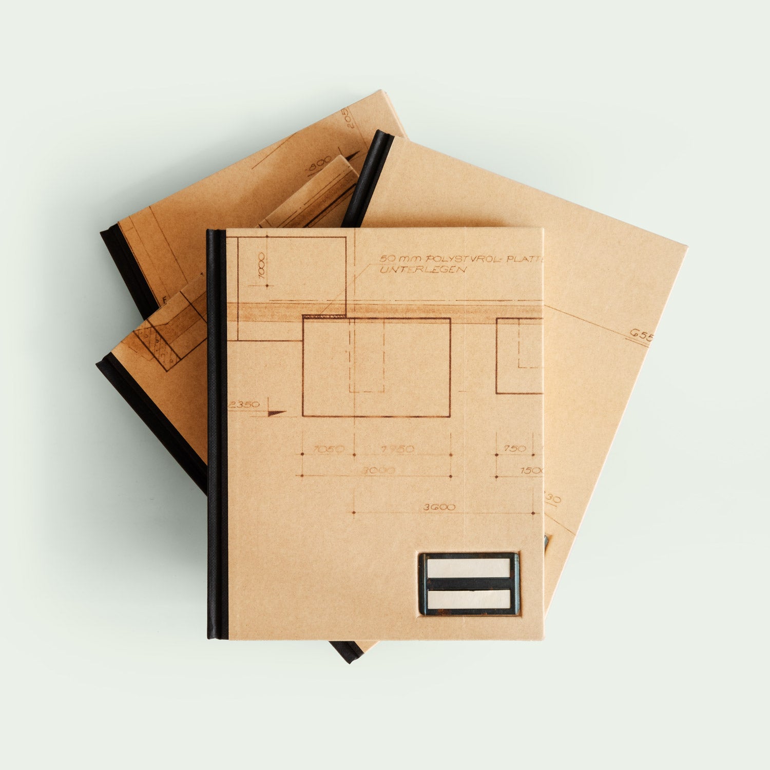 Vier Notizbücher mit technischem Zeichnungsdesign, übereinander gestapelt.