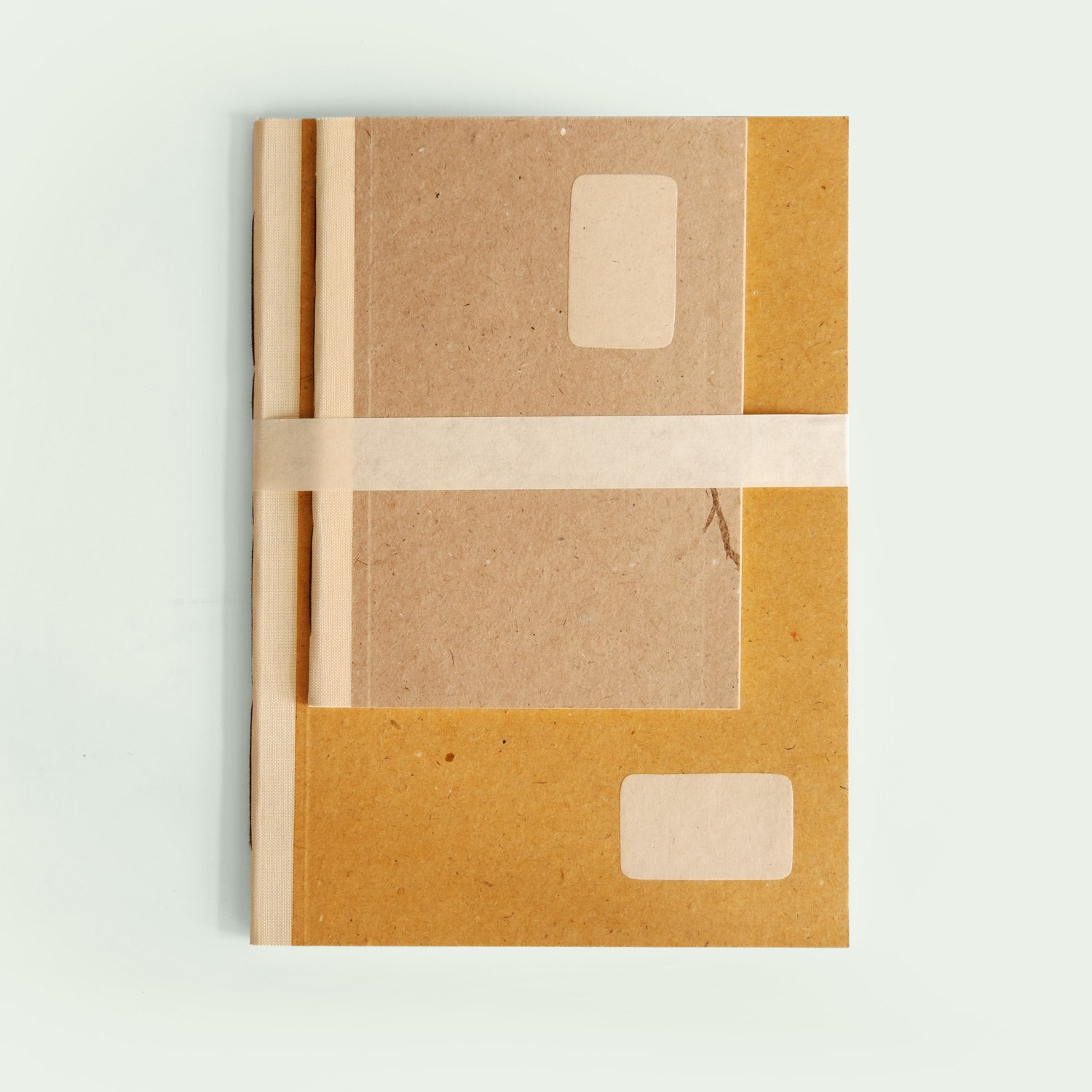 Ein zweiteiliges Notizbuch-Set von oben fotografiert. Die Bücher sind mit einem hellen Band zusammengebunden.