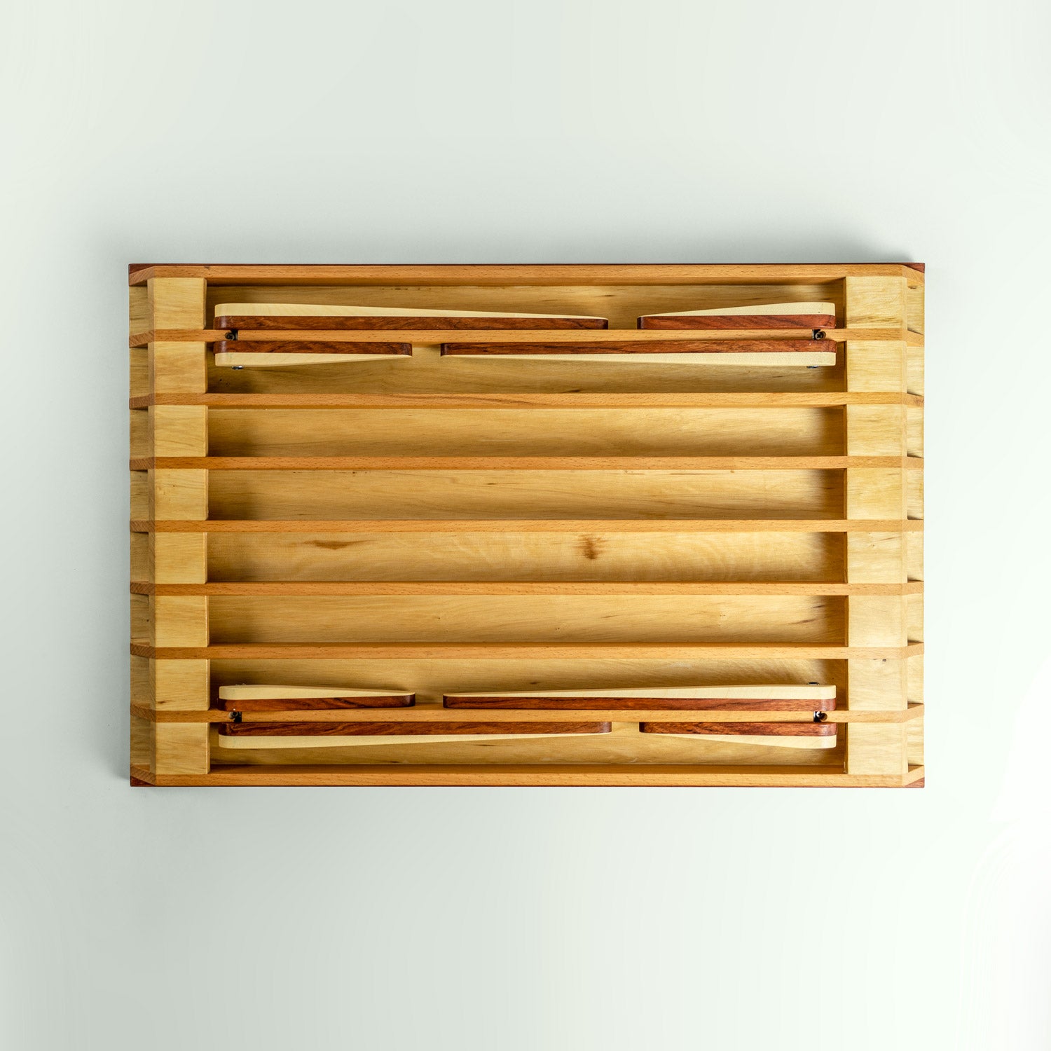 Ansicht der Unterseite des höhenverstellbaren Tabletttischs aus Rotbuche, Weissbuche und Bubinga.