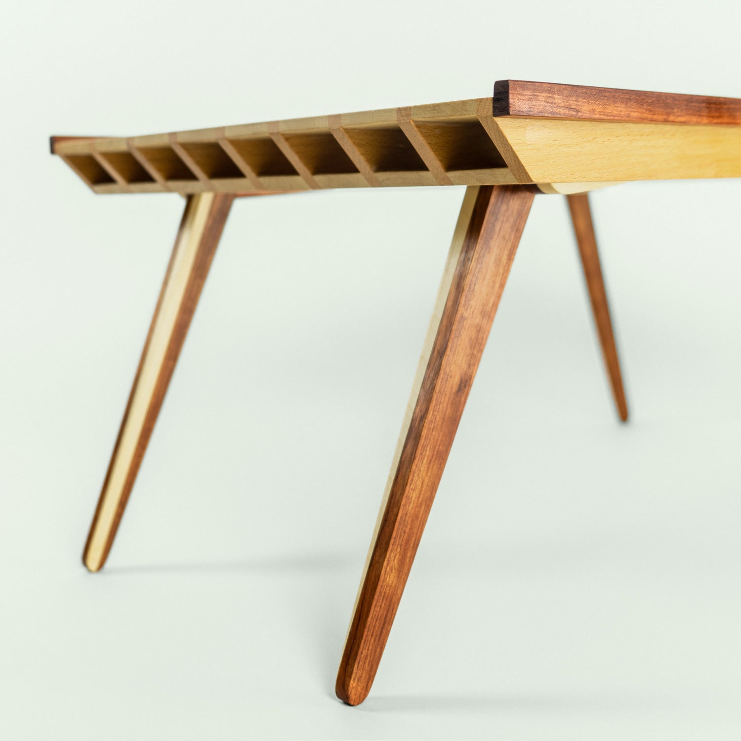 Detailansicht der Tischbeine des höhenverstellbaren Tabletttischs aus Rotbuche, Weissbuche und Bubinga.