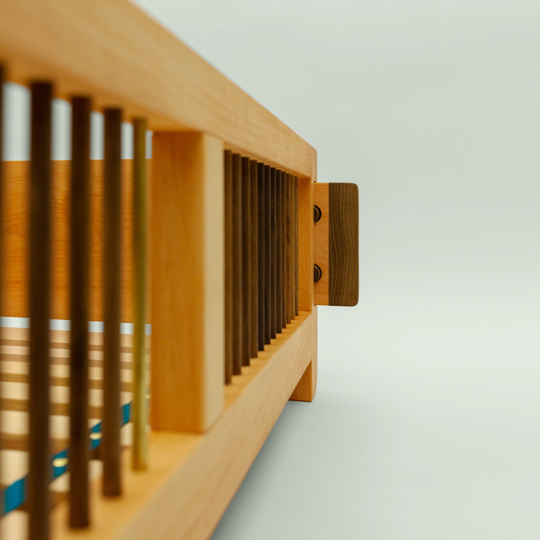 Das Bild zeigt die seitlichen Bettstreben aus Esche und Walnuss des Bettes "Liam". Die verschiedenen Holzarten ergänzen sich zu einem harmonischen Gesamtdesign.