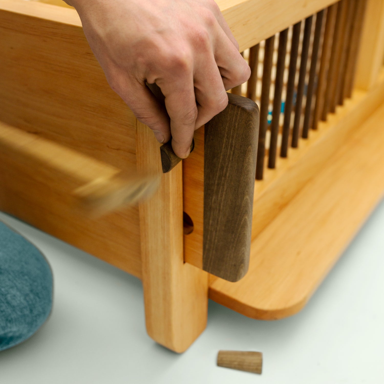 Nahaufnahme der Ecke des Montessori-Bettes "Liam", die die robuste Konstruktion und die harmonische Verbindung von Esche und Walnuss betont.