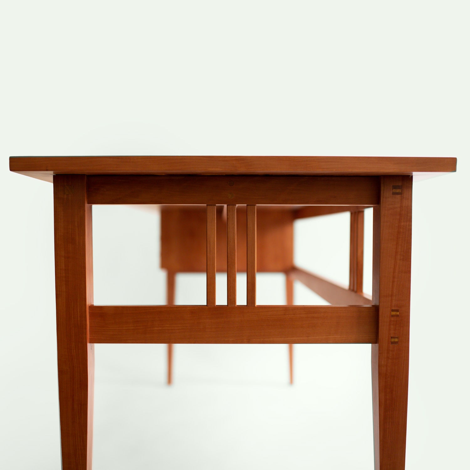 Seitliche Detailaufnahme des minimalistischen Designs des Tisches "Streuobstwiese" der Marke mimikry in Leipzig, gefertigt aus Elsbeere