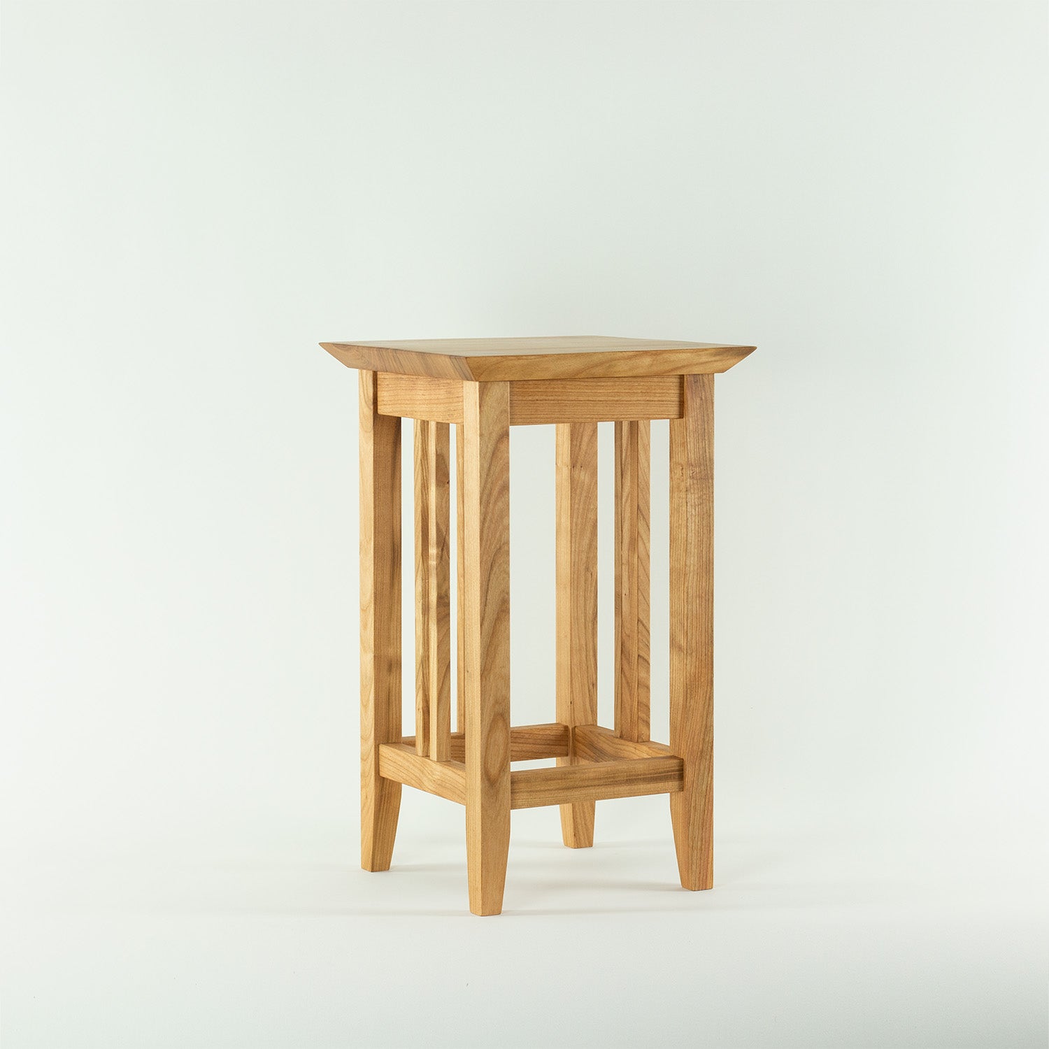 Handgefertigter Hocker aus natürlichen Materialien. Stabiler Holzhocker mit natürlicher Maserung. Aus Kirsche