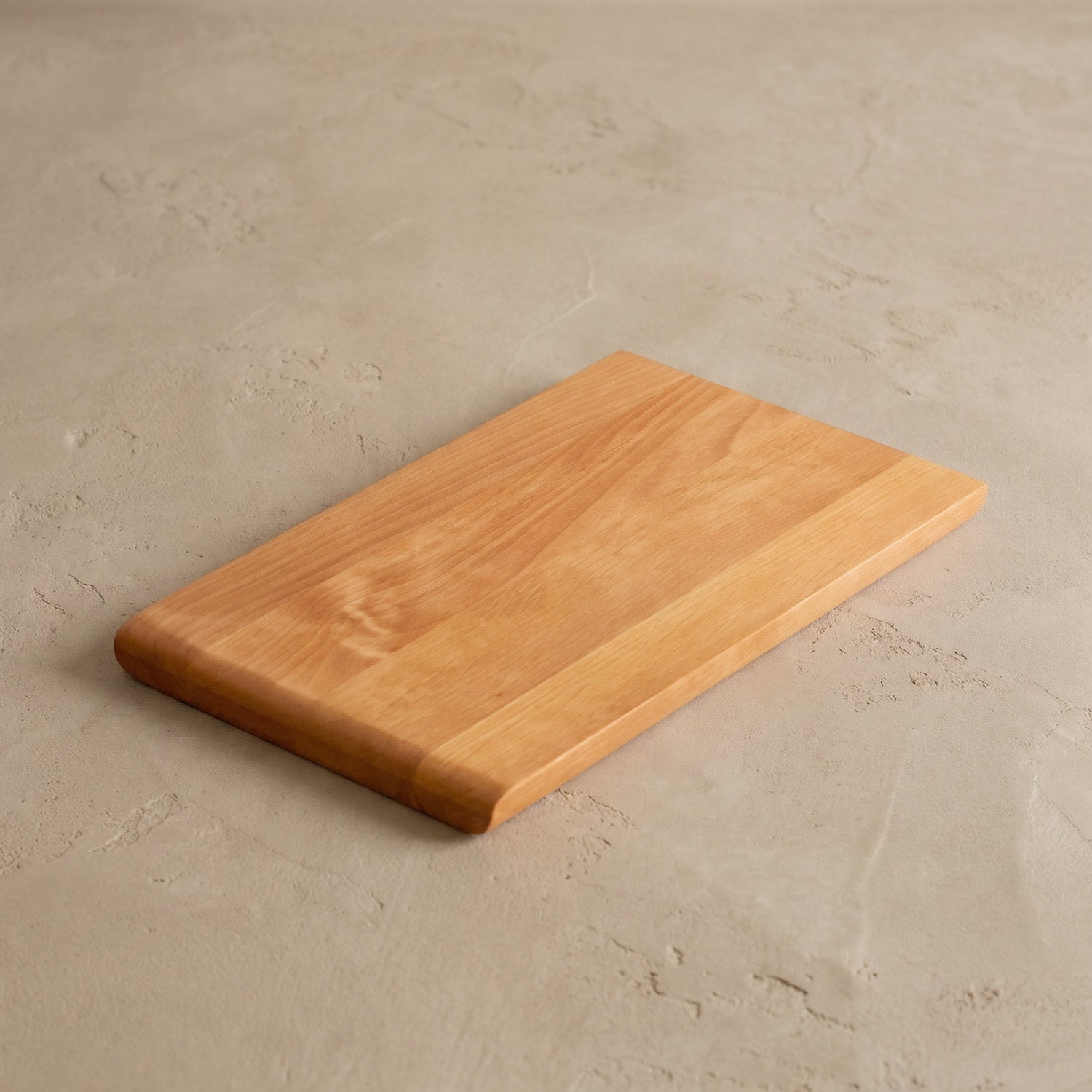 Schneidebrett Holz Erle Klein Aruna auf einem beigen Steinboden 02