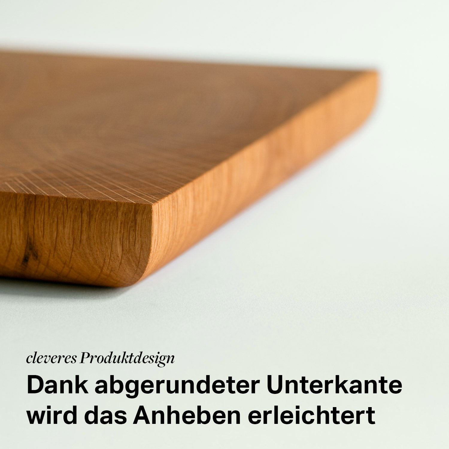 Detailansicht der kante eines Hirnholz Schneidebrettes aus Eiche mit dem Text darunter " Dank abgerundeter Unterkante wird das Anheben erleichtert"
